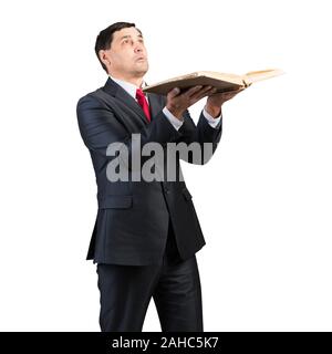 Senior Geschäftsmann holding Buch und oben zu schauen. Portrait von erwachsenen Mann in Anzug und Krawatte stehen auf weißen Hintergrund. Bildung und Wissen. Stockfoto