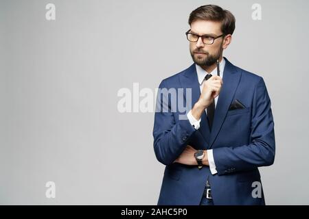 Studuo Schuss des Denkens Lösung Problem Geschäftsmann tragen Anzug halten Stift Stockfoto