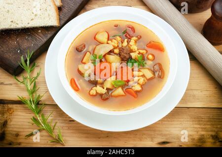Gulaschsuppe auf hölzernen Tisch Stockfoto