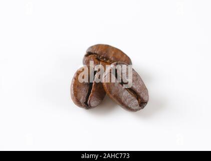 Drei geröstete Kaffeebohnen auf weißem Hintergrund Stockfoto