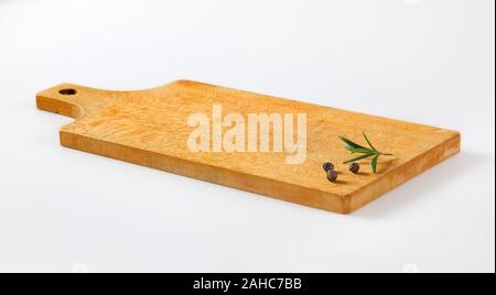 Holz Schneidebrett mit Rosmarin und schwarze Pfefferkörner auf es Stockfoto