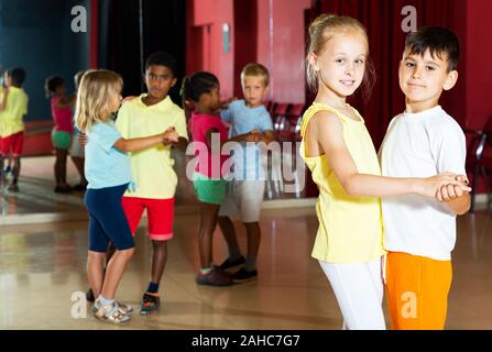 Lächelnde Kinder Grundschule versucht, Tanzen der Partner Tanz im modernen Studio Stockfoto