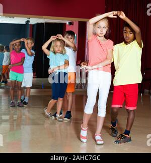Lächelnd glücklich positive Kinder Grundschule versuchen Salsa tanzen Tanz in modernen Studio Stockfoto