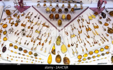 Verschiedene Beispiele für Schmuck aus Bernstein in Edelmetalle zum Verkauf angeboten auf Schaufenster Shop montiert Stockfoto