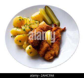 Gericht der Tschechischen Küche - hühnerschnitzel in Parmesan Paniermehl mit gekochten Kartoffeln und Gurken serviert. Auf weissem Hintergrund Stockfoto