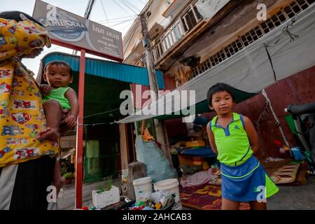 Eine asiatische Frau, die auf der Strasse leben Wer verdient ein Leben von Scavenging steht mit ihrem Jungen, ihre Kinder im Tierheim in Kampong Cham, Kambodscha Stockfoto