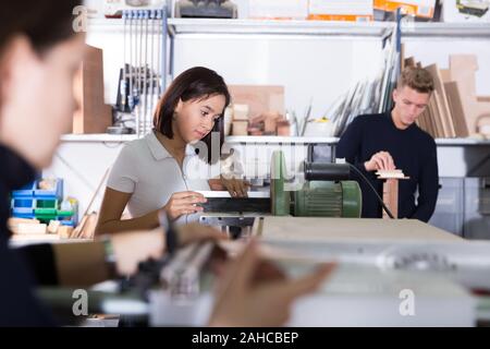 Junge weibliche Architekt polieren Elemente der zukünftigen architektonischen Modell im Design Bureau Stockfoto