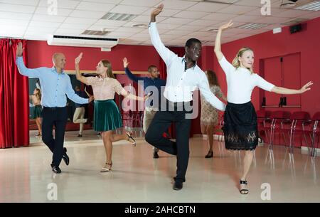 Paare von jungen Menschen üben twist Bewegungen im modernen Tanz Studio Stockfoto