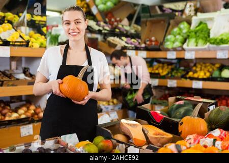 Junge zufrieden Frau mit Kürbis in Händen und Mann auf, die Hintergründe der Supermarkt Stockfoto