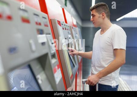 Porträt der jungen modernen über Terminal für den Kauf von Fahrkarten für die U-Bahn station Mann Stockfoto