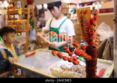 Hongkong, China. 28 Dez, 2019. Ein Kind kauft kandierte Haws an der 17 Hong Kong Food Festival in Hong Kong, South China, Dez. 28, 2019. Credit: Wu Xiaochu/Xinhua/Alamy leben Nachrichten Stockfoto