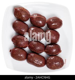 Im spanischen Stil raw morcilla (Blutwurst mit Reis) auf die weiße Platte. Auf weissem Hintergrund Stockfoto