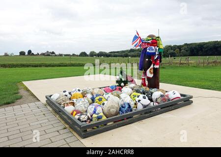 Die Leute gehen weg, Fußbälle und Club Andenken an die UEFA-Denkmal für die Weihnachten Waffenstillstand 1914 und Fußballspiele zwischen britischen und deutschen Soldaten Stockfoto