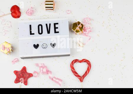 Leuchtkasten mit text Liebe, Dekoration, Geschenke, rote Lutscher und Ribbon. liebe Beichte, happy valentines day, Grußkarte, kopieren Platz für Text conce Stockfoto