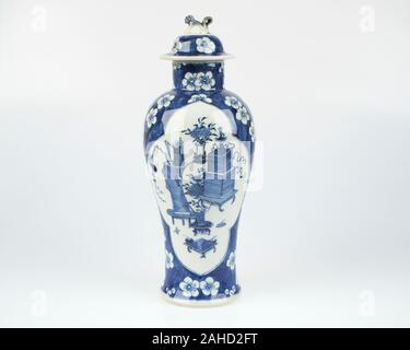 Antike chinesische Blau- und Weißporzellanvase und -Abdeckung, fein bemalt mit zwei Platten, die Vasen enthalten, die auf niedrigen Tischen sitzen. 22,5 cm hoch Stockfoto