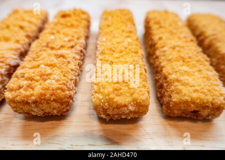 Nahaufnahme von fischstäbchen auf einer hölzernen Schneidebrett Stockfoto