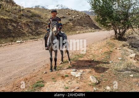 Naryn Region, Kirgisistan - Oktober 05, 2019: Kirgisischen ein Pferd reiten. Ein Mann reitet ein Pferd entlang der Kokemeren River. Kirgisistan. Stockfoto