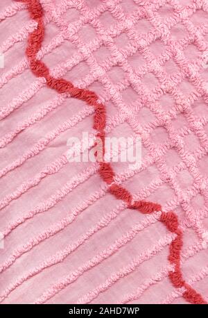 Antike Verblasst und abgenutzt, rosa gefärbte Chenillegewebe Tagesdecke. Dies ist eine hohe Auflösung alle Details Scan angezeigt. Stockfoto