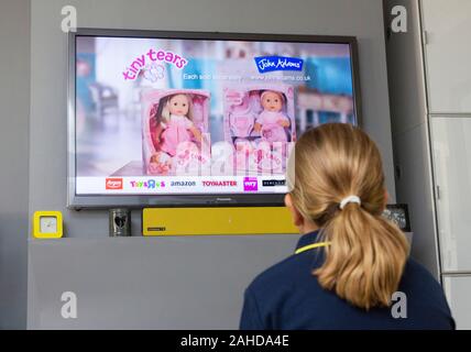 Junge Mädchen beobachten Werbung im Fernsehen Stockfoto