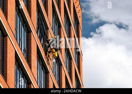 Unbekannte Berufe sind Windows Reinigung in einem Wolkenkratzer an einem sonnigen Tag Stockfoto