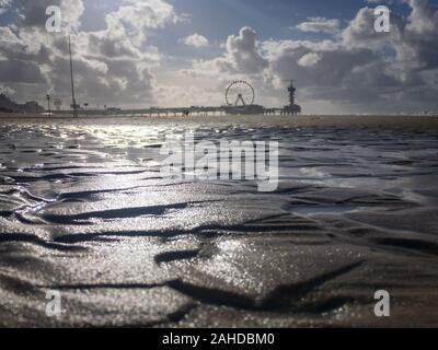 Low Angle View Strand von Scheveningen mit unscharfen Pier und Riesenrad im Hintergrund, die Niederlande Stockfoto