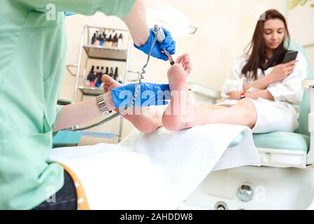 Frauenfüße, die ein Pediküre erhalten. Kosmetikerin macht Pediküre. Nahkonzept. Stockfoto