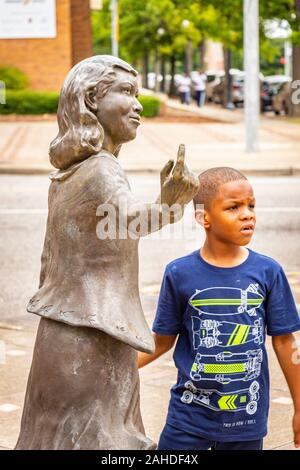 Schwarzer Junge neben der Statue eines Mädchens draußen am Birmingham Civil Rights Institute in Birmingham, AL, USA Stockfoto