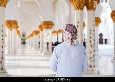 Arabischer Mann Besuch der Großen Moschee in Abu Dhabi traditionelles Kleid tragen Anzeigen Stockfoto