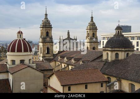 Dächer, Kuppeln und Türme historischer Gebäude in La Candelaria, Bogota, Kolumbien, mit La Catedral Primada und Capilla Sagraario im Vordergrund Stockfoto