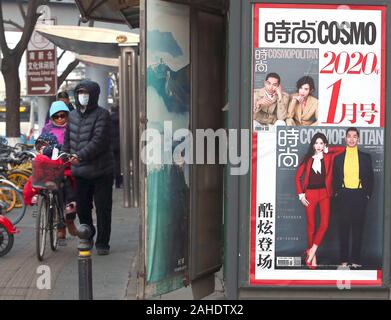 Peking, China. 28 Dez, 2019. Chinesische vorbei einen news Kiosk sowohl chinesische als auch internationale Magazine auf einer Straße in der Innenstadt von Peking Verkauf am Samstag, 28. Dezember 2019. American Lifestyle Zeitschriften, vor allem derjenigen, die sich mit westlichen Lebensstil, Promis und Mode in China sehr populär sind, mit den meisten ausländischen Zeitschriften in eine chinesische Version ihre Deckung der populären Kultur. Foto von Stephen Rasierer/UPI Quelle: UPI/Alamy leben Nachrichten Stockfoto