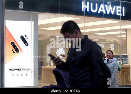 Peking, China. 28 Dez, 2019. Chinesische Spaziergang, vorbei an einem Huawei store in der Innenstadt von Peking am Samstag, 28. Dezember 2019. Chinesische tech giant Huawei, mit Blick auf anstehende US-Strafanzeige und wirtschaftliche Sanktionen, plant seine Telekommunikation Abteilung Forschung in den Vereinigten Staaten nach Kanada zu Neuvergabe, Gründer Sen Zhengfei in einem Interview gesagt. Foto von Stephen Rasierer/UPI Quelle: UPI/Alamy leben Nachrichten Stockfoto