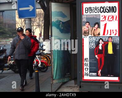 Peking, China. 28 Dez, 2019. Chinesische vorbei einen news Kiosk sowohl chinesische als auch internationale Magazine auf einer Straße in der Innenstadt von Peking Verkauf am Samstag, 28. Dezember 2019. American Lifestyle Zeitschriften, vor allem derjenigen, die sich mit westlichen Lebensstil, Promis und Mode in China sehr populär sind, mit den meisten ausländischen Zeitschriften in eine chinesische Version ihre Deckung der populären Kultur. Foto von Stephen Rasierer/UPI Quelle: UPI/Alamy leben Nachrichten Stockfoto