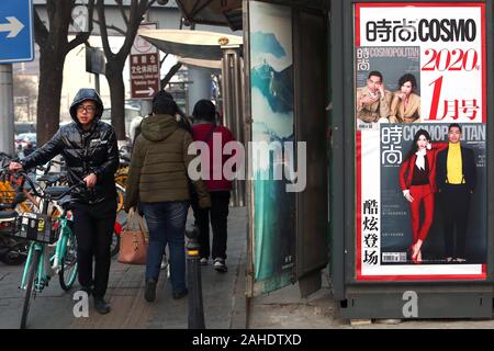 Peking, China. 28 Dez, 2019. Chinesische vorbei einen news Kiosk sowohl chinesische als auch internationale Magazine auf einer Straße in der Innenstadt von Peking Verkauf am Samstag, 28. Dezember 2019. American Lifestyle Zeitschriften, vor allem derjenigen, die sich mit westlichen Lebensstil, Promis und Mode in China sehr populär sind, mit den meisten ausländischen Zeitschriften in eine chinesische Version ihre Deckung der populären Kultur. Foto von Stephen Rasierer/UPI Quelle: UPI/Alamy leben Nachrichten Stockfoto