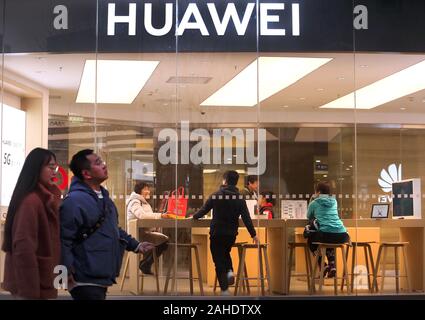 Peking, China. 28 Dez, 2019. Chinesische Spaziergang, vorbei an einem Huawei store in der Innenstadt von Peking am Samstag, 28. Dezember 2019. Chinesische tech giant Huawei, mit Blick auf anstehende US-Strafanzeige und wirtschaftliche Sanktionen, plant seine Telekommunikation Abteilung Forschung in den Vereinigten Staaten nach Kanada zu Neuvergabe, Gründer Sen Zhengfei in einem Interview gesagt. Foto von Stephen Rasierer/UPI Quelle: UPI/Alamy leben Nachrichten Stockfoto