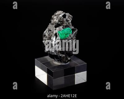 Rock mit raw Smaragd Kristall mit schwarzem Hintergrund Stockfoto