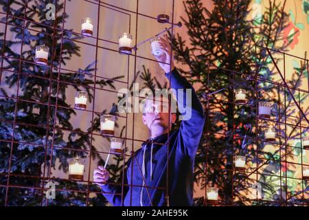 Wroclaw, Polen. 28 Dez, 2019. Ein freiwilliger Lichter der Kerzen für das Abendgebet. Rund 15.000 Pilger aus Europa und darüber hinaus in Wroclaw in Polen für die jährlichen Europäischen Jugendtreffen der Gemeinschaft von Taizé unter dem Motto "Pilgerweg des Vertrauens auf der Erde" zusammengestellt. Die Gemeinschaft von Taizé ist eine interkonfessionelle christliche Orden aus Frankreich. (Foto von Michael Debets/Pacific Press) Quelle: Pacific Press Agency/Alamy leben Nachrichten Stockfoto