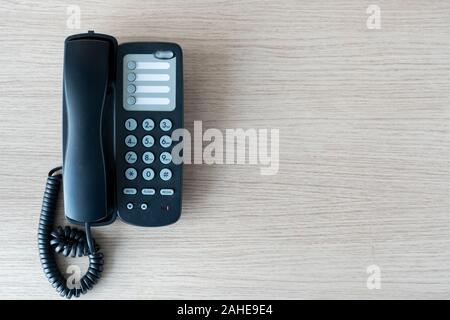 Die alten schwarzen Telefons im Business Office Desk im Holz für den Kontakt herstellen, oben auf der Tabelle oben Mitarbeiter verwendet werden, warten darauf, von Cu zu hören Stockfoto