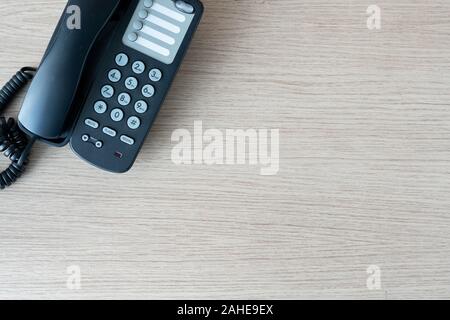 Die alten schwarzen Telefons im Business Office Desk im Holz für den Kontakt herstellen, oben auf der Tabelle oben Mitarbeiter verwendet werden, warten darauf, von Cu zu hören Stockfoto