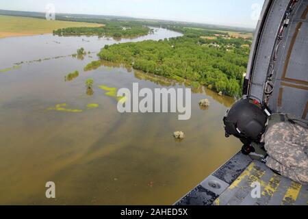 Sgt. John vorrath, Charlie Company, 2. Der 147. Aviation Battalion, Iowa Army National Guard, betreibt eine Schlinge an einem UH-60 Blackhawk über dem geschwollenen Missouri River. Iowa National Guard Soldaten vom Central Iowa haben auf Zustand aktiv verpflichtet werden, lokale und staatliche Behörden in den westlichen Iowa Stadt Sioux City, Iowa zu unterstützen, und North Sioux City, S.D. Wachposten von der Iowa National Guard arbeiten mit ihren Zähler Teile aus dem South Dakota National Guard private Eigenschaften und Kommunen entlang der geschwollenen Missouri River zu schützen. Flug Besatzungen aus Charlie Company 2. Stockfoto