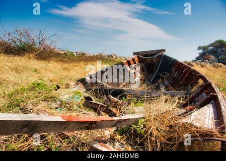 Auf diesem einzigartigen Foto sehen Sie ein altes zerbrochenes Fischerboot aus Holz, das die Natur wieder erholt! Stockfoto