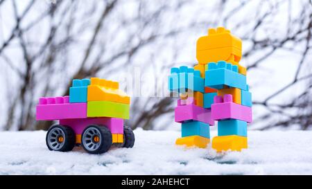 Winter neues Jahr Kinder Spielzeugauto und Roboter. Spielzeug im Schnee auf der Straße. Weihnachten Geschenke. Stockfoto