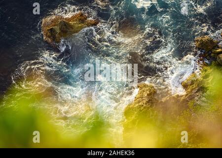 (Selektive Fokus) Ansicht von oben, atemberaubenden Blick auf die felsige Küste im Hintergrund vom türkisfarbenen Meer bei Sonnenuntergang getaucht. Stockfoto