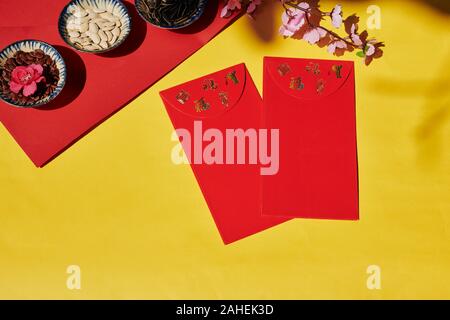 Flatlay von Tet feier Tabelle mit Lucky Money Umschläge und Schalen verschiedener Samen Stockfoto