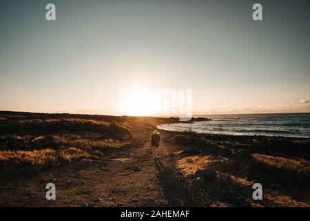 Frauen Wanderungen bei Sonnenaufgang am Meer. Stockfoto