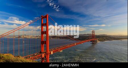 Panorama von der Golden Gate Bridge bei Sonnenuntergang mit Marin Headlands im Vordergrund, San Francisco Skyline und bunten Wolken im Hintergrund Stockfoto