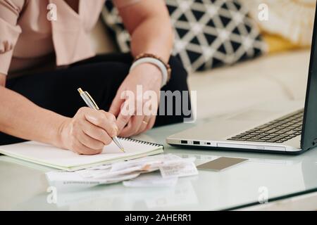 Zugeschnittenes Bild der älteren Frau, die ihre Rechnungen und gehaltsschecks Kontrolle ihr Budget zu verwalten Stockfoto