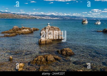 Felsige Küste und Felsbrocken aus dem Wasser herausragt. Opatija. Kroatien Stockfoto
