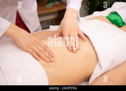 Die Frau, die Body Massage in Bambus Spa empfängt. Bauch Therapie, horizontal Stockfoto