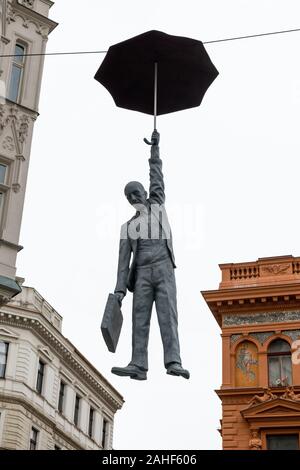 Hängende Mann mit Regenschirm Skulptur namens leichte Unsicherheit von Michal Trpak in Prag (Tschechische Republik) Stockfoto