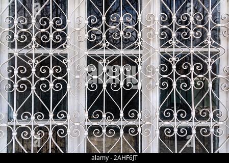 Geschmiedete Schutzgitter aus Metall auf einem alten Fenster Stockfoto